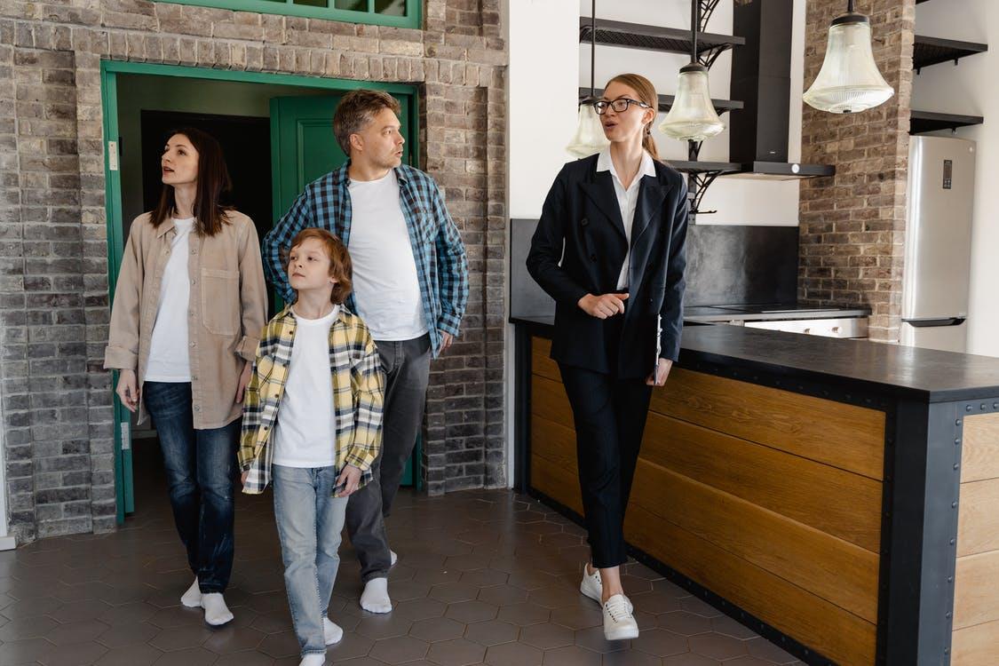 A real estate agent giving home tour to a small family.